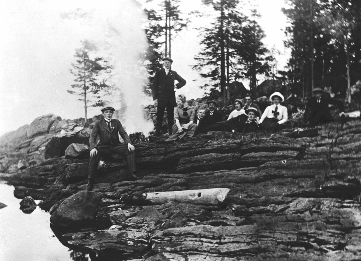 Anno Domkirkeodden, Stor gruppe på landtur har pause på bergknaus. Foran er Karl Løken Jr. Kan være på Langodden, Brumunddal.