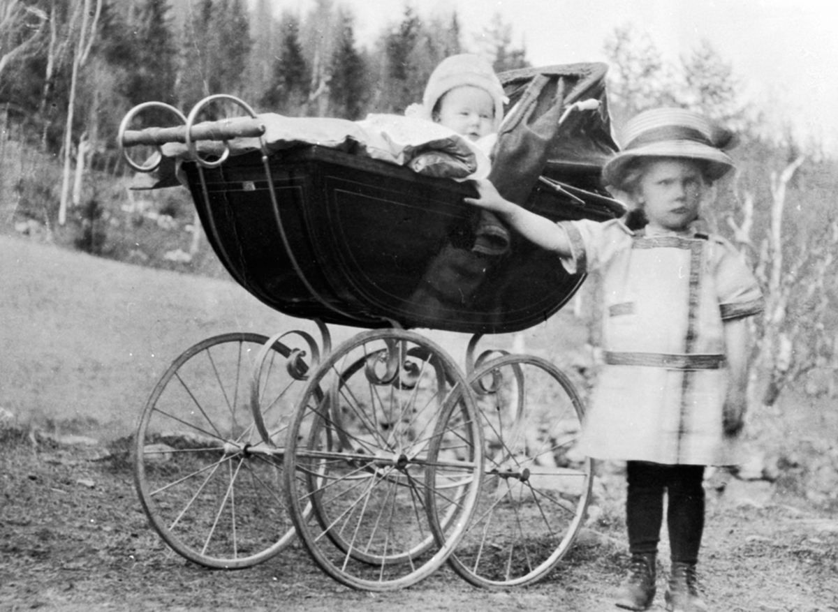 Anno Domkirkeodden, To barn ved amerikansk barnevogn. Marie Engen ved vogna, Julie Engen (gift Hovdhaugen) i vogna. Vognen var amerikansk tatt med hjem av Jørgen Engen.
