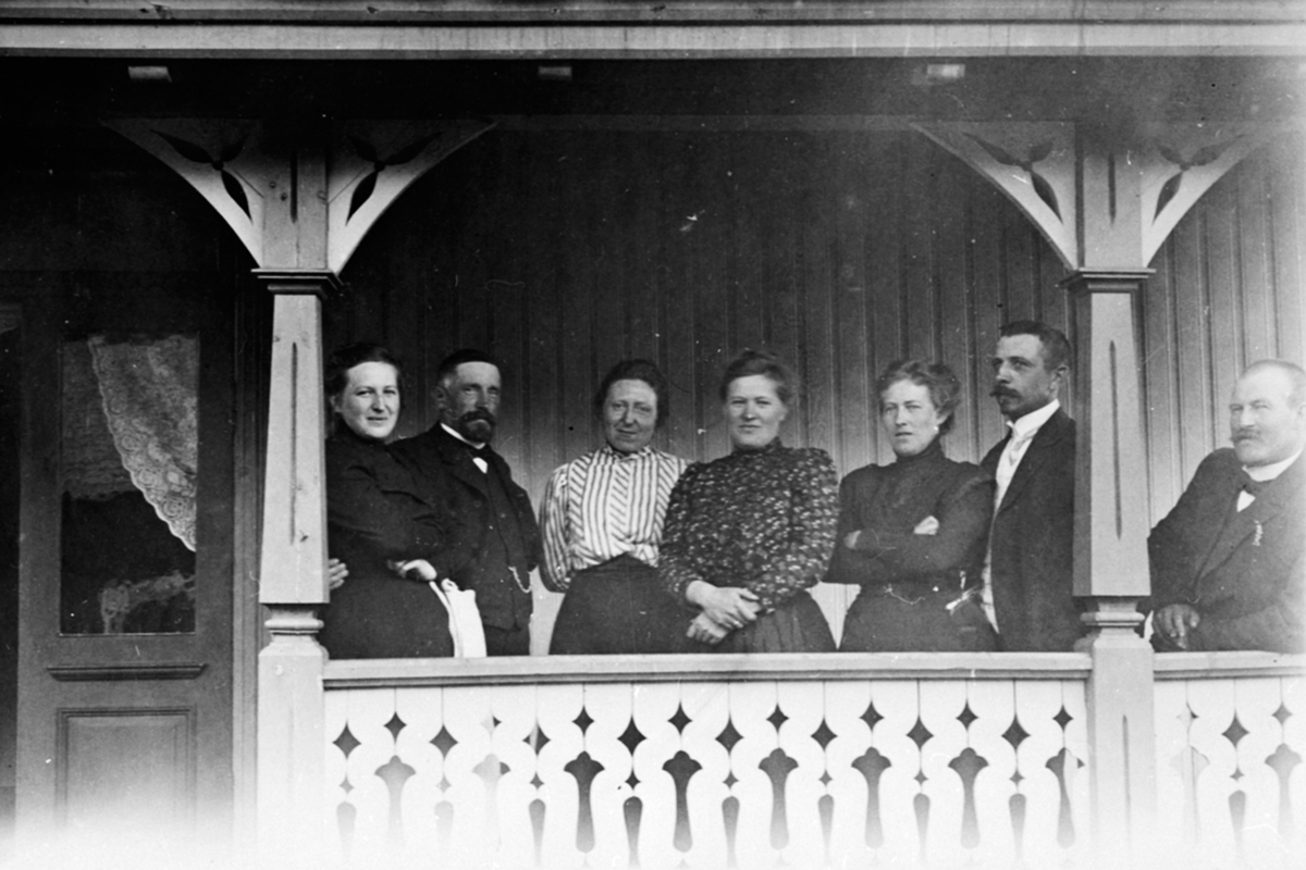 Anno Domkirkeodden, Gruppe voksne på verandaen på Haugen, Veldre, Ringsaker. Fra venstre er Antonette Ring (født Hersoug), Ole Løken, Agnethe Ring (født Jahren), Mimi Løken (født Ring), Barbra Skappel (født Ring), Halvor Skappel, Barthold Henrik Todderud. Ole Løken satte opp Haugen til sine svigerforeldre i 1904.