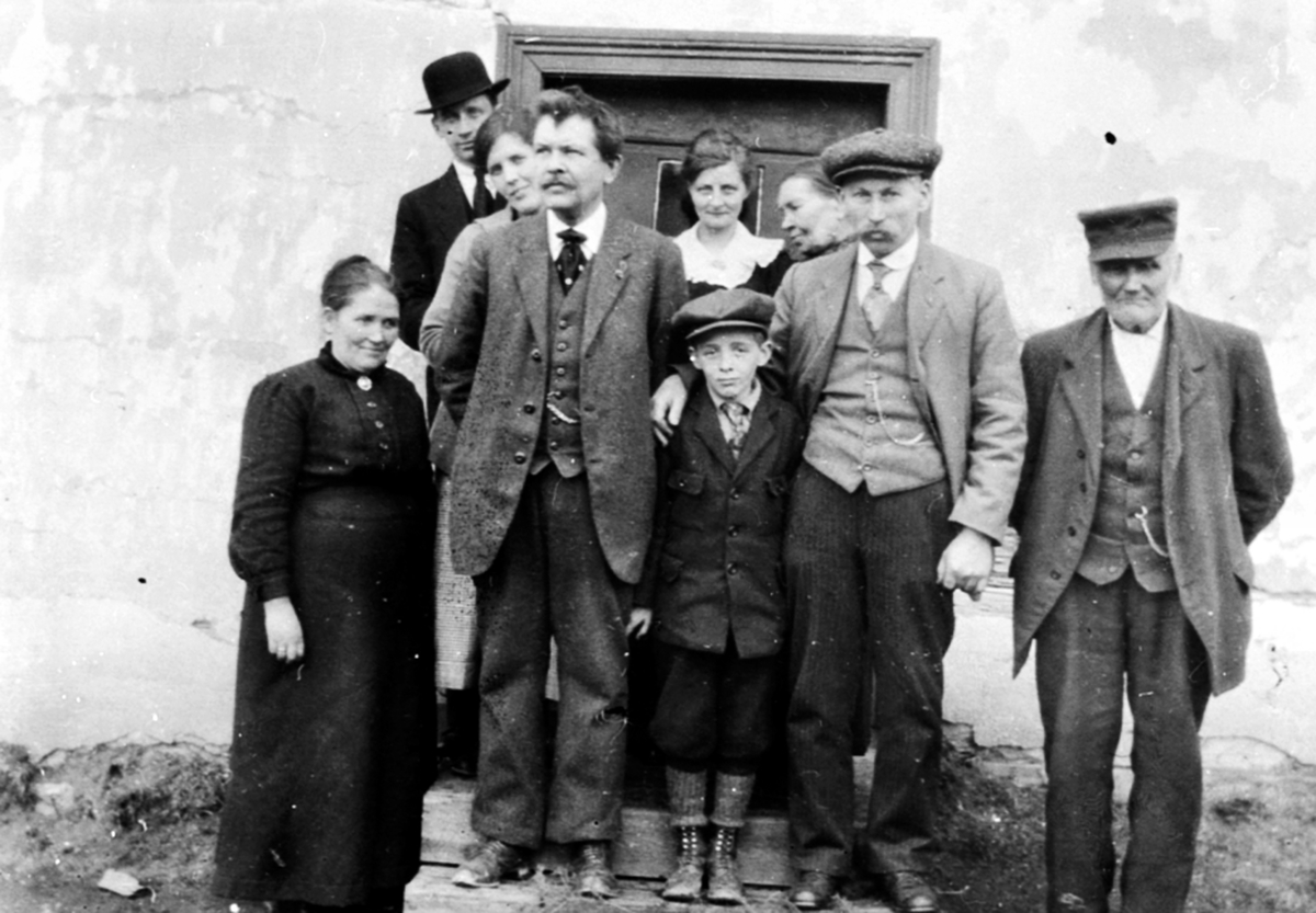 Anno Domkirkeodden, Gruppe personer utenfor Sundby lille, Skredderbakken, Helgøya. Fra venstre er Marit Sæhlie, Anders Aas, Asbjørn Aas, Ole Sæhlie, Johannes Akselsen. Bak fra venstre Ole Møystad med hatt, Marie Møystad, Guri Aas, Marit Jensdatter.