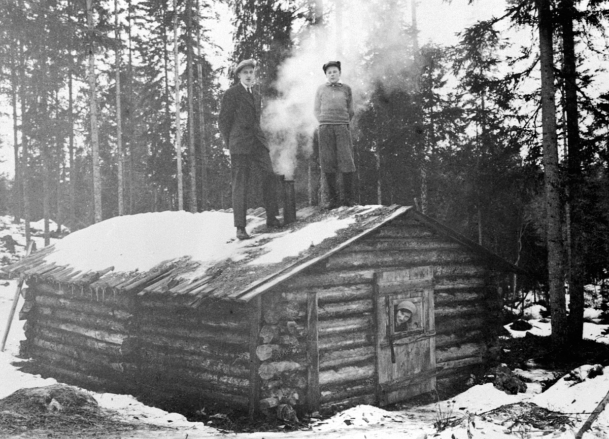 Anno Domkirkeodden, Eksteriør, tømmerkoie, ljørkoie i Ringsakerfjellet. På taket er Sverre Baardseth og Grønvold-gutt. Ukjent kvinne i døra.