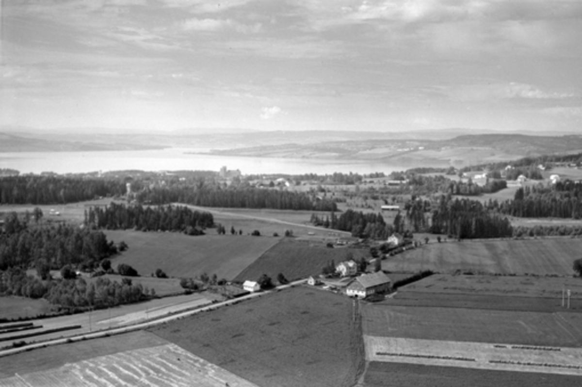 Anno Domkirkeodden, Flyfoto,landskap, Furne.. Vallsig Vestre langs Benterudbakken i forkant, Hamar kornsilo i bakgrunnen. Kontrolltårnet på Hamar flyplass i venstre bildekant.