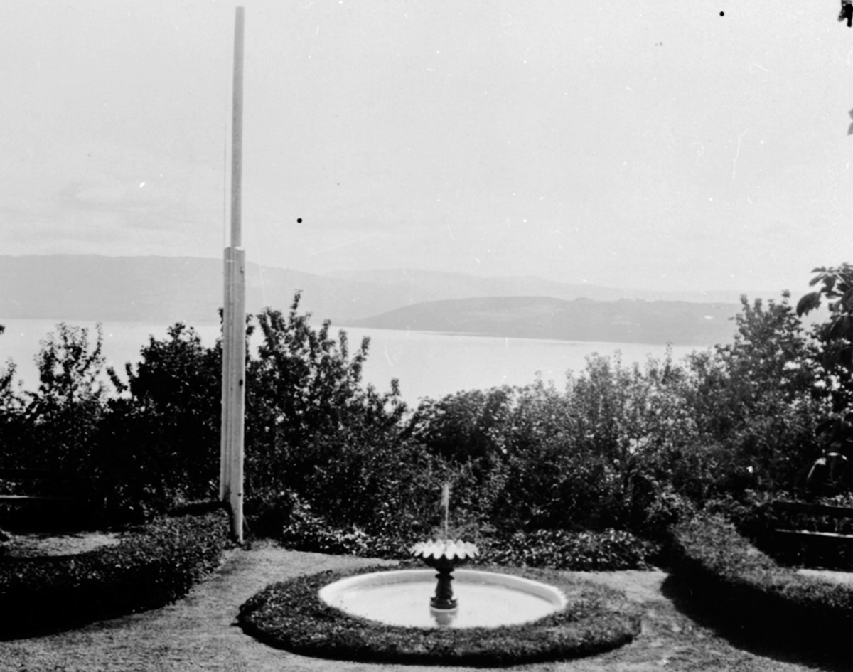 Anno Domkirkeodden, Utsikt over Mjøsa mot Toten og Skreia fra hagen på Hovelsrud, Helgøya. Vannfontene og flaggstang.