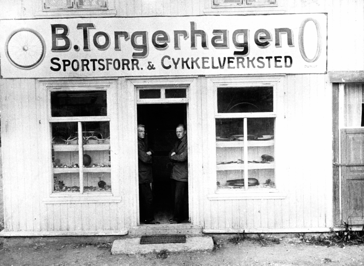 Anno Domkirkeodden, Inngangsparti til B.Torgerhagen sportsforretning & sykkelverksted. I døra er Mikkel (23.2 1887) og Bernhard Torgerhagen (2.9 1898), Stampen, Brumunddal.
