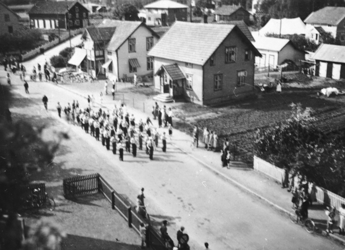 Anno Domkirkeodden, Brumunddal guttemusikk marsjerer forbi Skalmerudkafeen og baker Evensen, Ringsakervegen, Brumunddal.