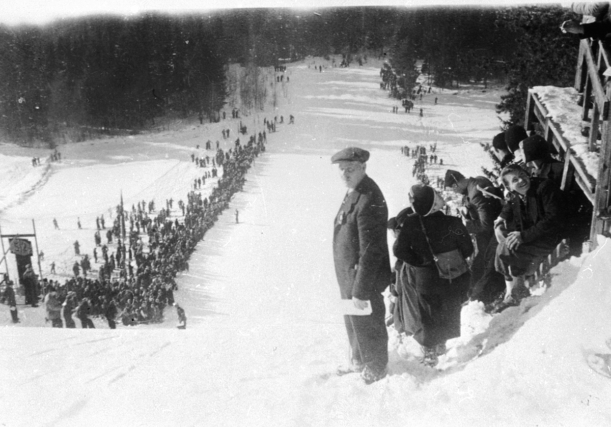 Anno Domkirkeodden, Mye folk i Frambakken, Brumunddal. Idrettslaget Fram sin hoppbakke. Formann i skigruppa Emil Kristiansen.Hovedlandsrennet i 1928. Det var hovedlandsrenn i 1924, 1928, 1930.