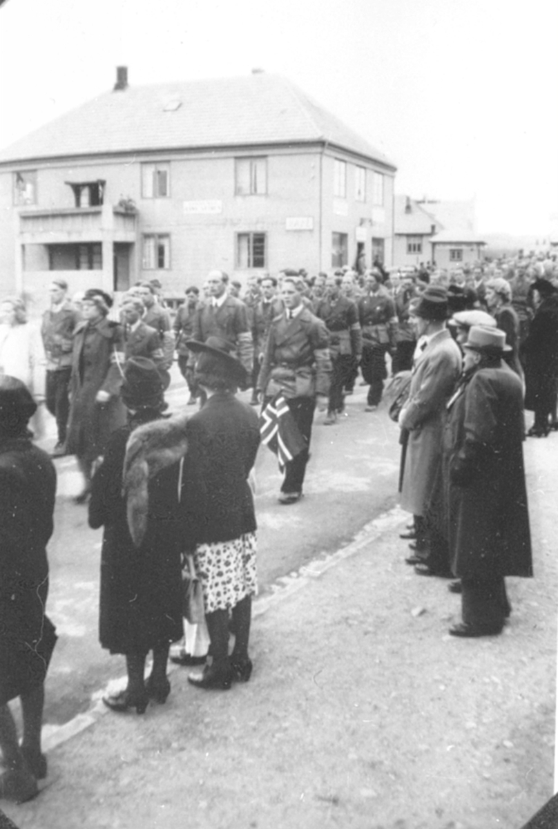 Anno Domkirkeodden, 17. maitog 1945, hjemmefronten marsjerer i Furnesvegen, Brumunddal foran Promenadekafeen.