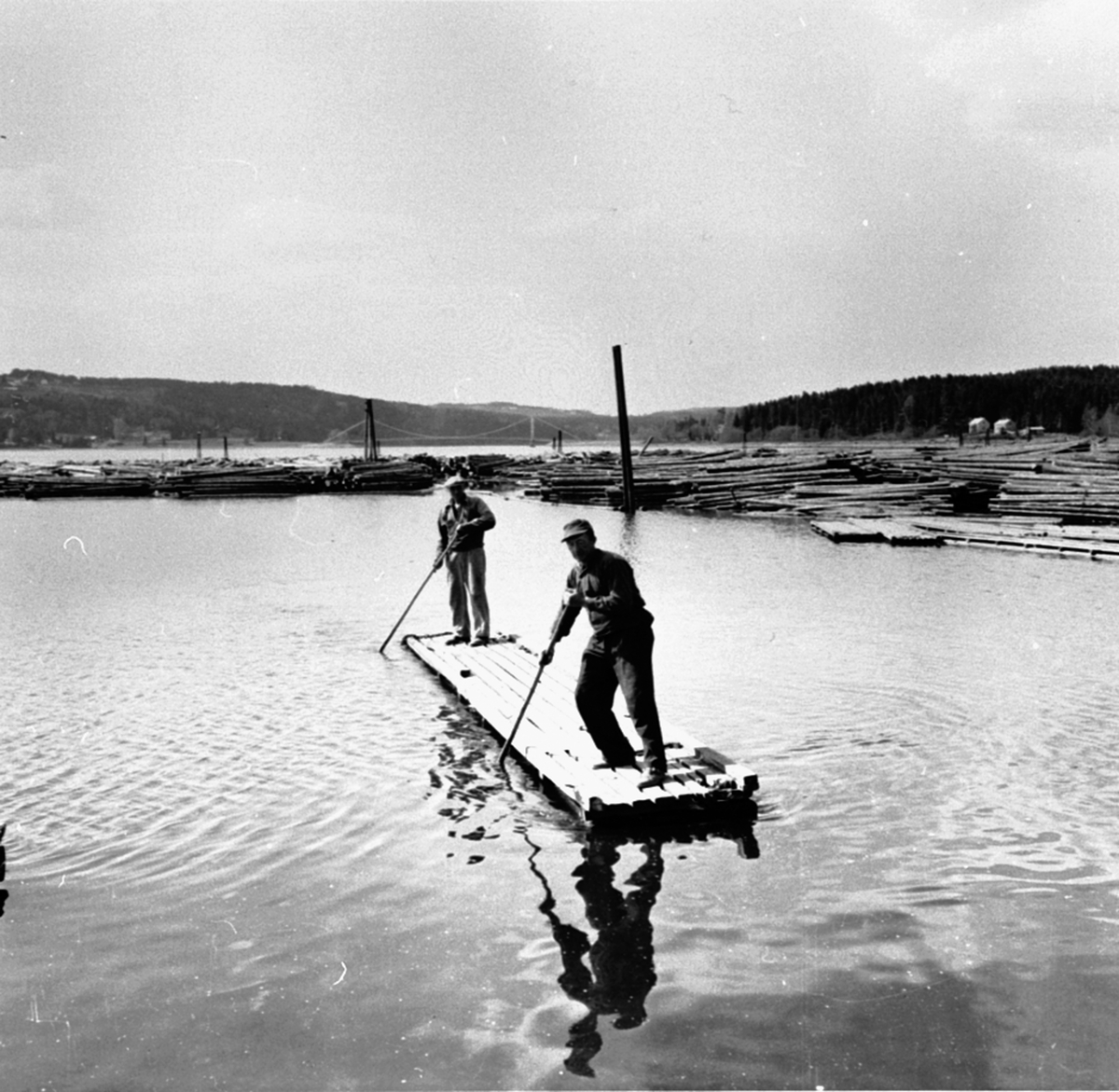 Anno Domkirkeodden, 2 menn på flåte ved strandsaga, Berger Langmoen A/S, Brumunddal. Raagnar Bakken foran, Gunvald Asmundsen bak.