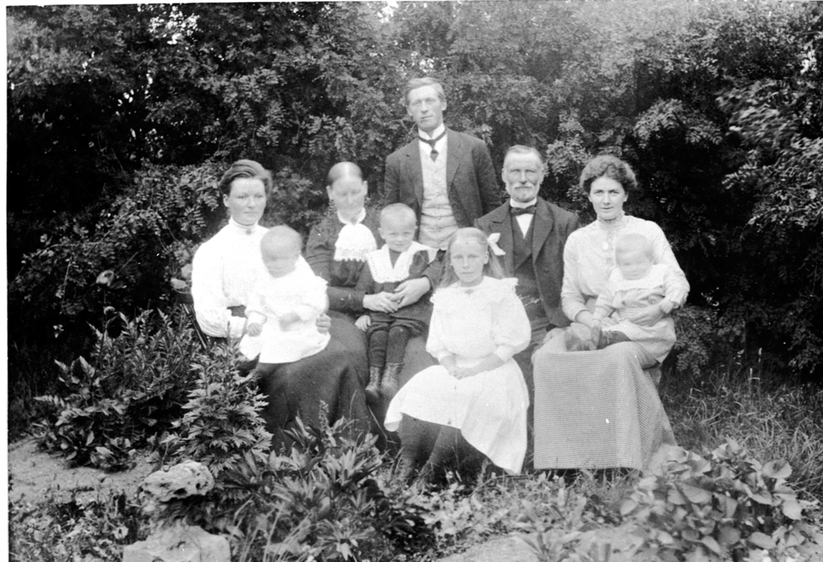 Anno Domkirkeodden, Gruppe voksne og barn. Fra venstre er Sofie Bye med Jørgen Bye på fanget, Olava Bye med Eivind Bye på fanget, Hans Bye, Olga Bye Dokken, Even Bye, Marie Bye med Even på fanget, Veldre, Ringsaker.
