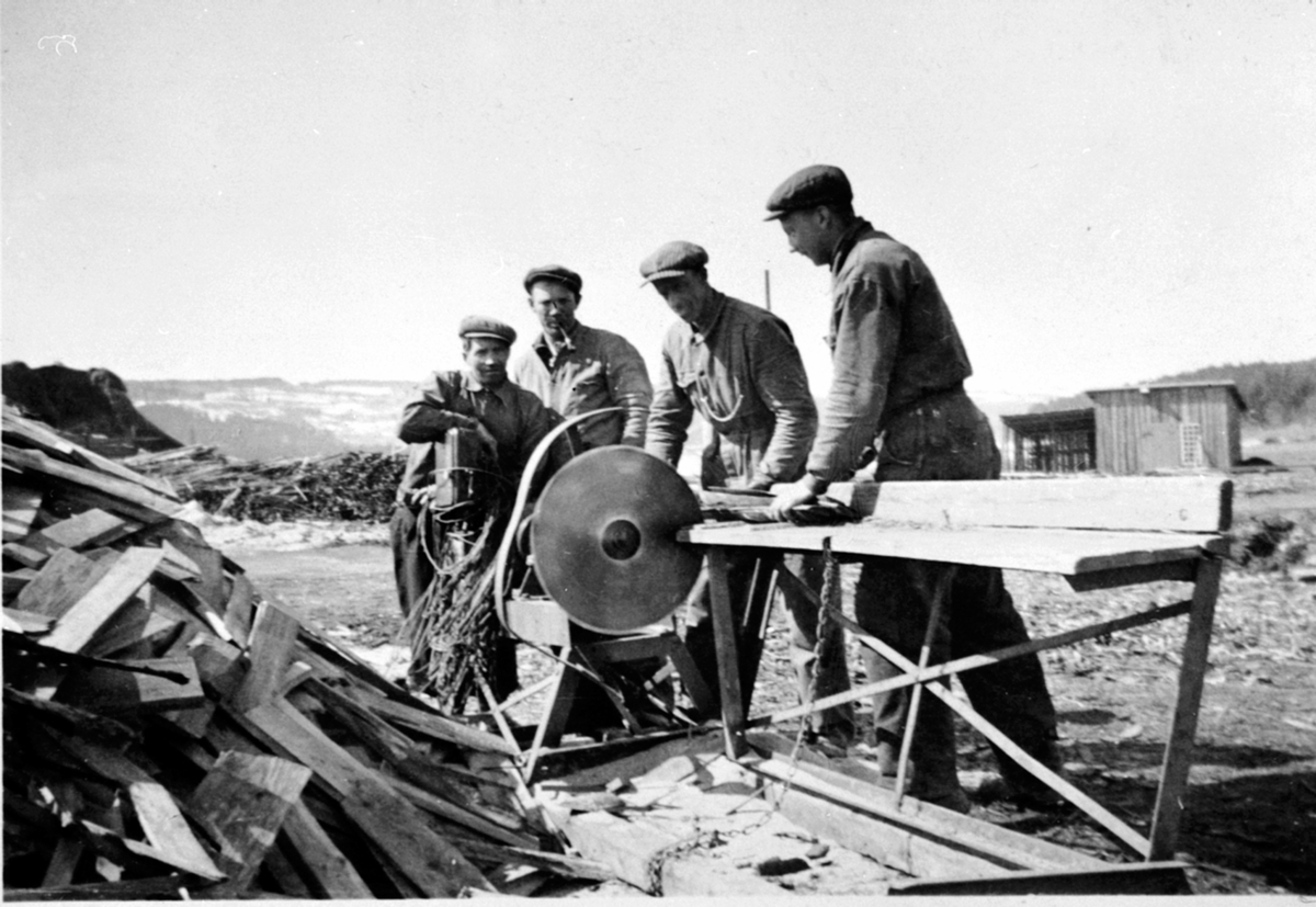 Anno Domkirkeodden, Vedkapping med kappsag. Fra venstre er Georg Holter, Karl Strand, Olaf Kjeldsrud, Paul Myhre. Strandsaga, Berger Langmoen A/S, Brumunddal.