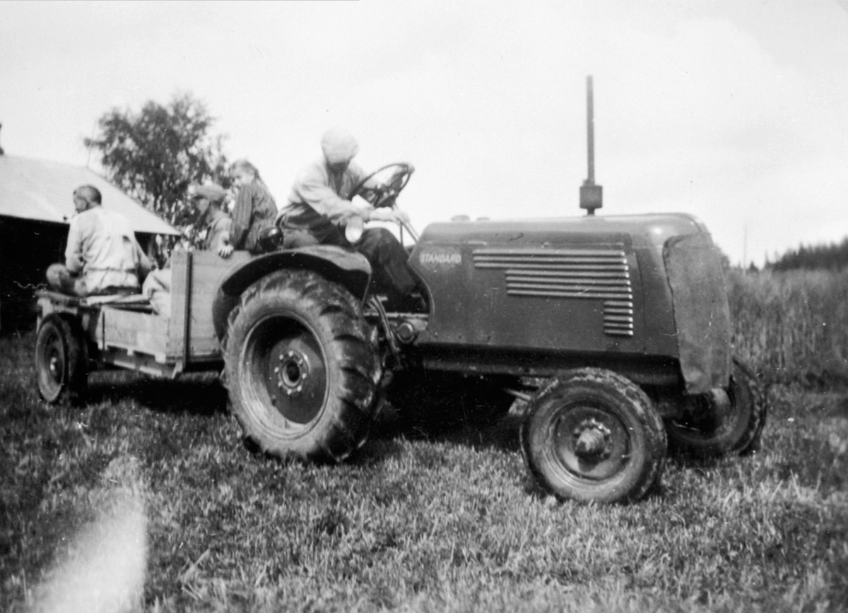 Anno Domkirkeodden, Standard traktor med henger på Rognstad gård, Veldre, Ringsaker. Fører er Berdon Kvisberg. på hengeren er Kåre Solbjørg, Lars Ekeberg, Bjørg Petra Kvisberg.