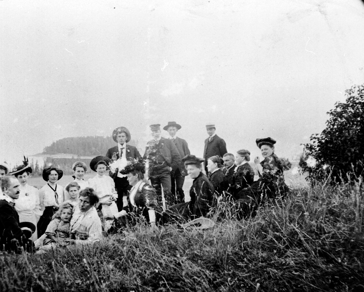 Anno Domkirkeodden, Stor gruppe voksne og barn på Hovinsholm, med utsikt mot Hovinsholmen, Helgøya.