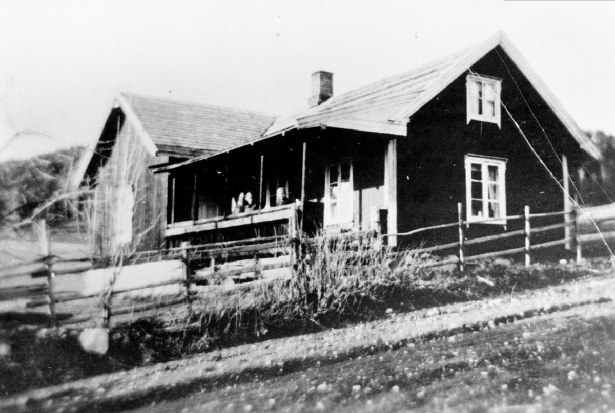 Anno Domkirkeodden, Det gamle huset i Ås, Helgøya før ombygging, på tomt fradelt Enger. 3 personer på veranda.