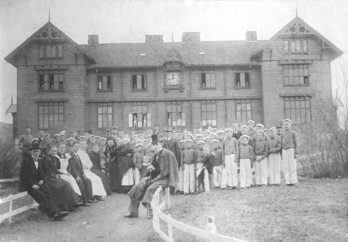 Anno Domkirkeodden, Stor gruppe lærere, betjening foran hovedbygningen på Toftes Gave, Nedre Sund, Helgøya. Noen av guttene i uniformen til korpset. Navneliste foreligger på registreringsskjema.
