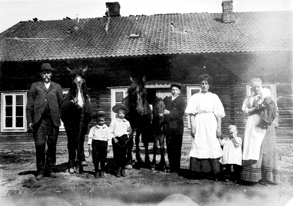 Anno Domkirkeodden, Utendørs på Syverud gård, Solbergåsen, Nes, Hedmark. Fra venstre er Lars H. Fossum f.1875, Leonard Fossum f. 1906, Hans Østby f.1905, ukjent, Maren "pige", Karen Fossum f.1909, Gund Fossum f.1874 med Dorthea F.1911 på armen.