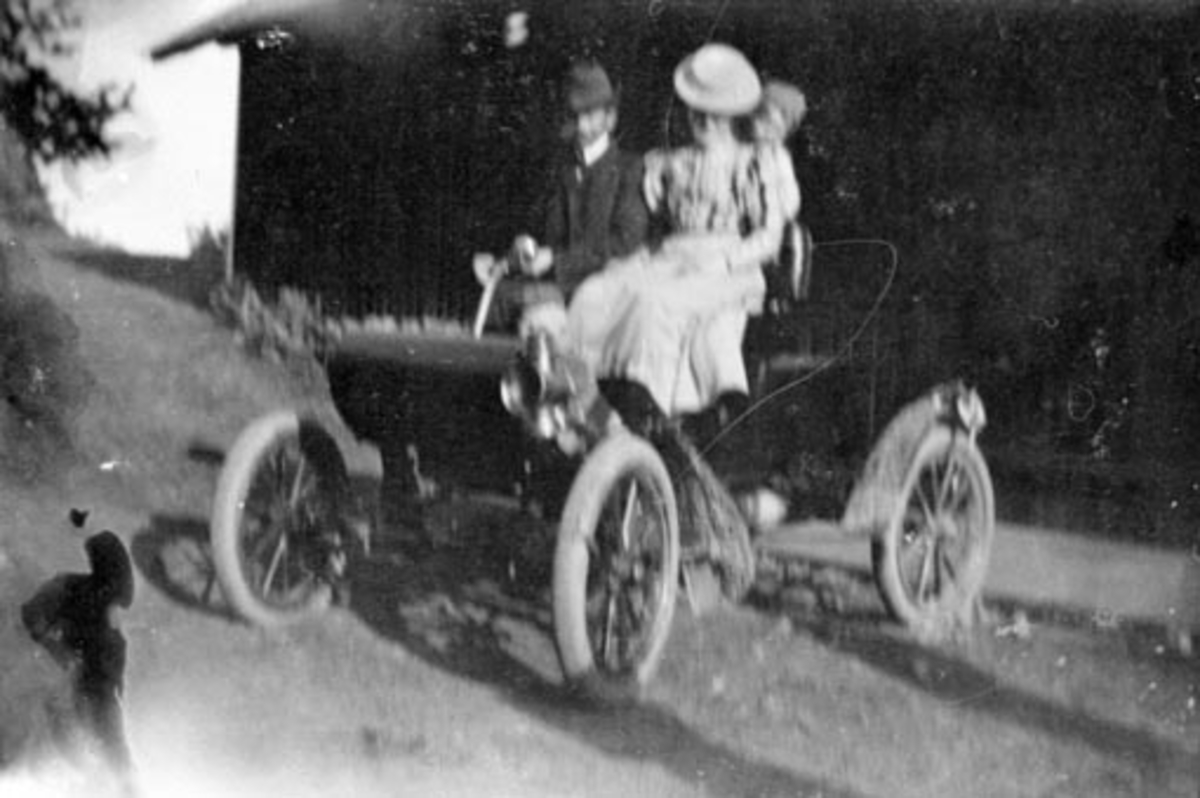 Anno Domkirkeodden, Dyrlege Heggenhaugen med familie. Garden første bil, en Oldsmobile. Hilstad øvre, Stavsjø, Hedmark. ---- kommentar start ---- Dette bildet viser så vidt jeg kan se en Oldsmobile 1903. Det er IKKE samme bil som på det andre bildet! Skjærmene er forskjellige, og hjulene ser ut til å ha en annen still…