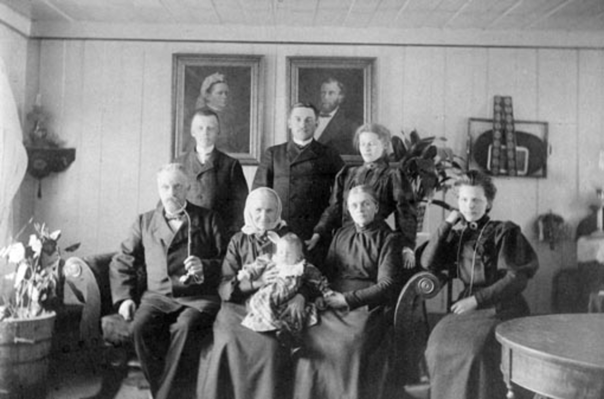 Anno Domkirkeodden, Interiør frå spisestugua i Nordgarden Østal (Ousdal) på Nes 1906. Sitjande f. v. : Mons Ousdal (1858 - 1937), Berte Ousdal f. Eik (1825 - 1916) med oldebarnet sitt, Oddlaug Nøkleby (1906 - 2006) på fanget, Hanna Ousdal f. Heggen (1856 - 1949) og Louise Ousdal (1889 - ). Ståande f. v. : Jørgen Ousda…