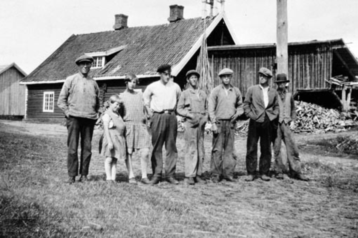 Anno Domkirkeodden, Voksne og barn foran drengestua på Hoelstad, Nes, Hedmark. Til venstre er gardskar gjennom mange år, Johan Olsen Stensbakk (1890-1970). Nummer tre fra venstre er hans datter Malfrid f. 1914. Den vesle jenta er Astrid Boye f.1921, datter på garden.