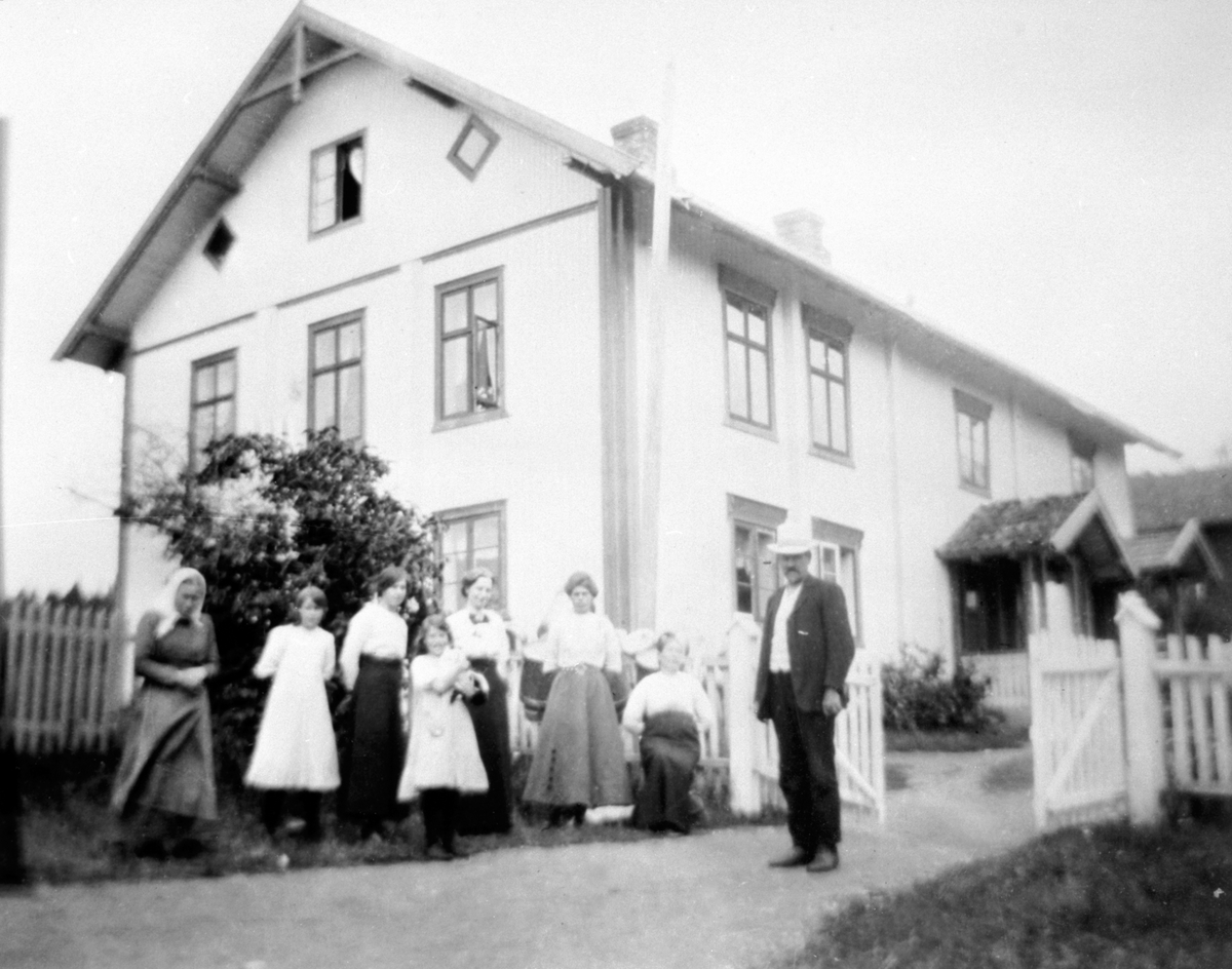 Anno Domkirkeodden, Den gamle hovedbygningen på Bredvold, Nes, Hedmark. Revet. Fra venstre er Juline, Marthe (1866-1950), Anne, Inga (1901-1980), Olga Olsen, Marie Fløttum, Ida (1856-1939) og Martinus Bredvold (1858-1935).