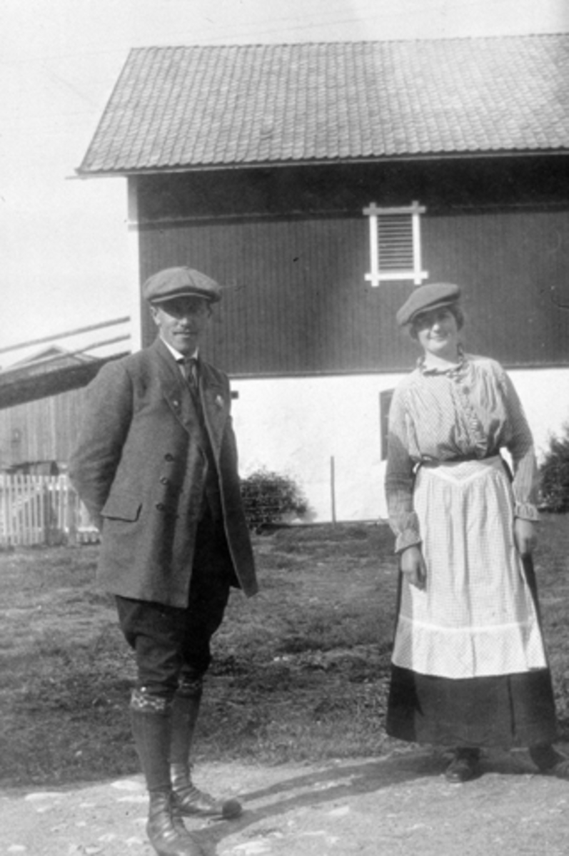 Anno Domkirkeodden, Einar Søberg fra Løten og Kristine Langmyhr på tunet på Buttekvern gård, Brumunddal. Låven med låvebru i bakgrunn.