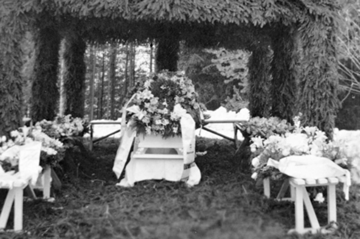 Anno Domkirkeodden, Begravelse etter Even Arnt lie (1865-1938), Smedstuen nedre, Nes, Hedmark. Barsal etter lokket er satt på kista. Pyntet med kranser og blomster, pute med sølvkors.