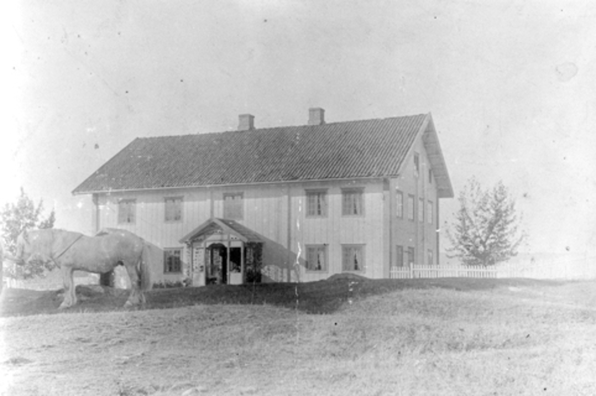 Anno Domkirkeodden, Eksteriør. Hovedbygningen på Kinne nedre, Brøttum, Ringsaker. Mann med hest i forgrunnen.