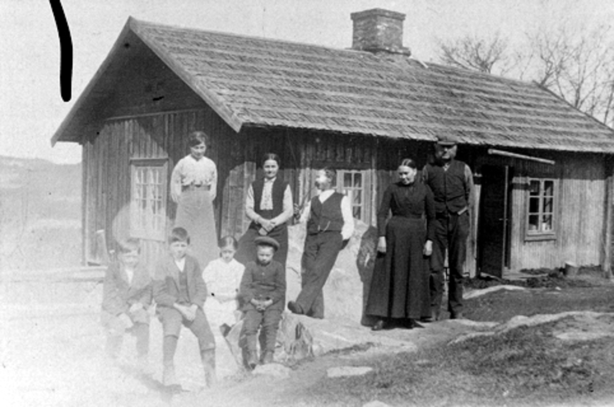 Anno Domkirkeodden, Eksteriør, husmannsplassen Ballinstuggua under Syljuåshagen, Vestli, Brøttum, Ringsaker. Havikfamilien foran stua. Johan og Sina med barna. Den andre plassen under Syljuåshagen het Kongestuggua.