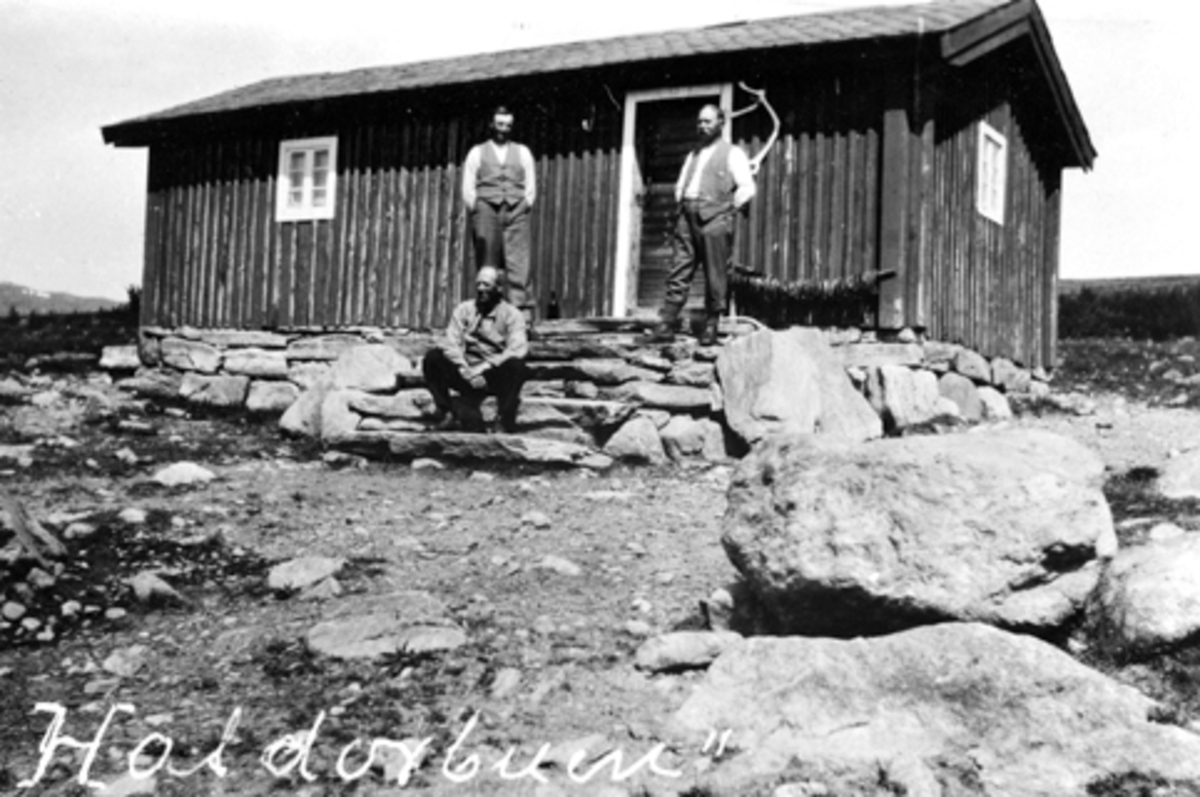 Anno Domkirkeodden, Eksteriør. Hestegjeterhytte i Ringsakerfjellet. Haldorbuen. Tre menn utenfor.