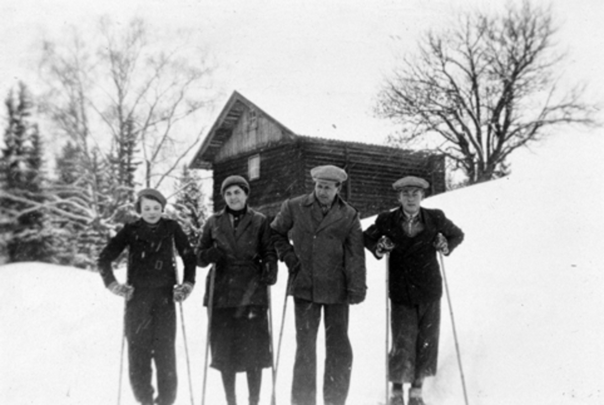 Anno Domkirkeodden, Skitur foran et av stabburene på Bjørnstad, Nes, Hedmark. Folkene er trolig fra venstre Ingrid (1922-1946), Anna Margrethe (1892-1980), Asbjørn (1882-1967) og Erling Feiring (1915-1988).