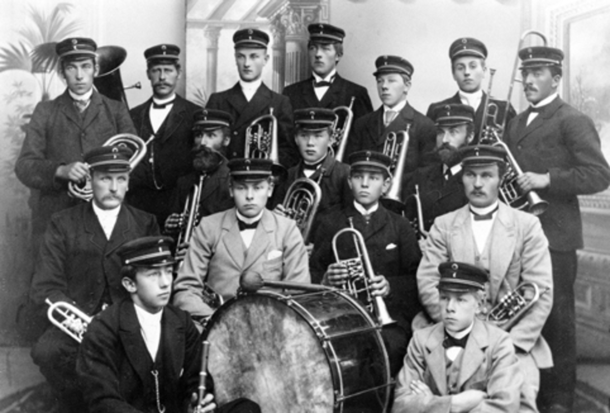 Anno Domkirkeodden, Moelv Musikkforening, ca. 1895-1898. Sittende foran er Otto Henig og Halfdan Grønvold. Andre rekke Simen G. Ruud, Lars Grønvold, Børre Skjønsberg og Anton Lysrud. Tredje rekke Peder Pedersen, August Pettersen og Even Eng. Fjerde rekke Petter M. Amblie, Johan Bjørke, Lars Pedersen, Fjeldhammer, Hans…