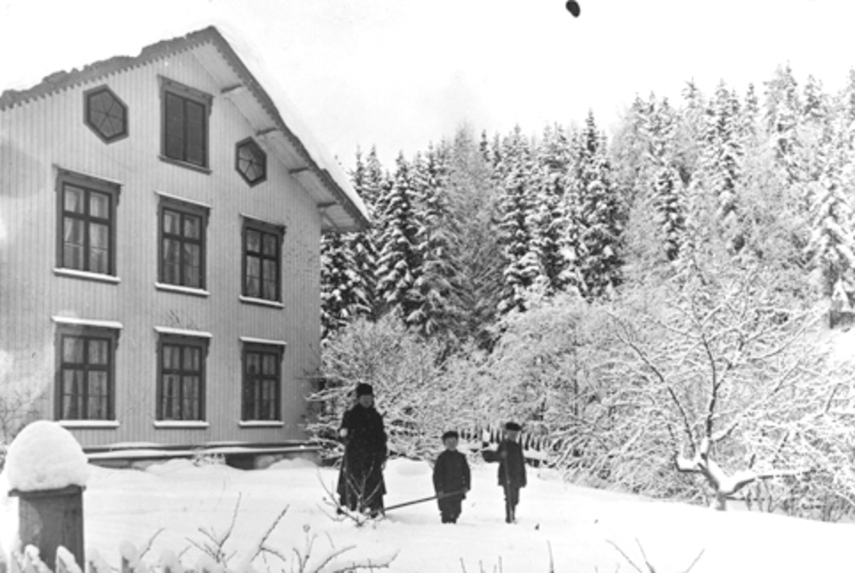 Anno Domkirkeodden, Bruvold, Moelv. Laura Sundgaard med sønnene Ivar og Gunnvald i hagen foran hovedbygningen, vinter, ca. 1910.