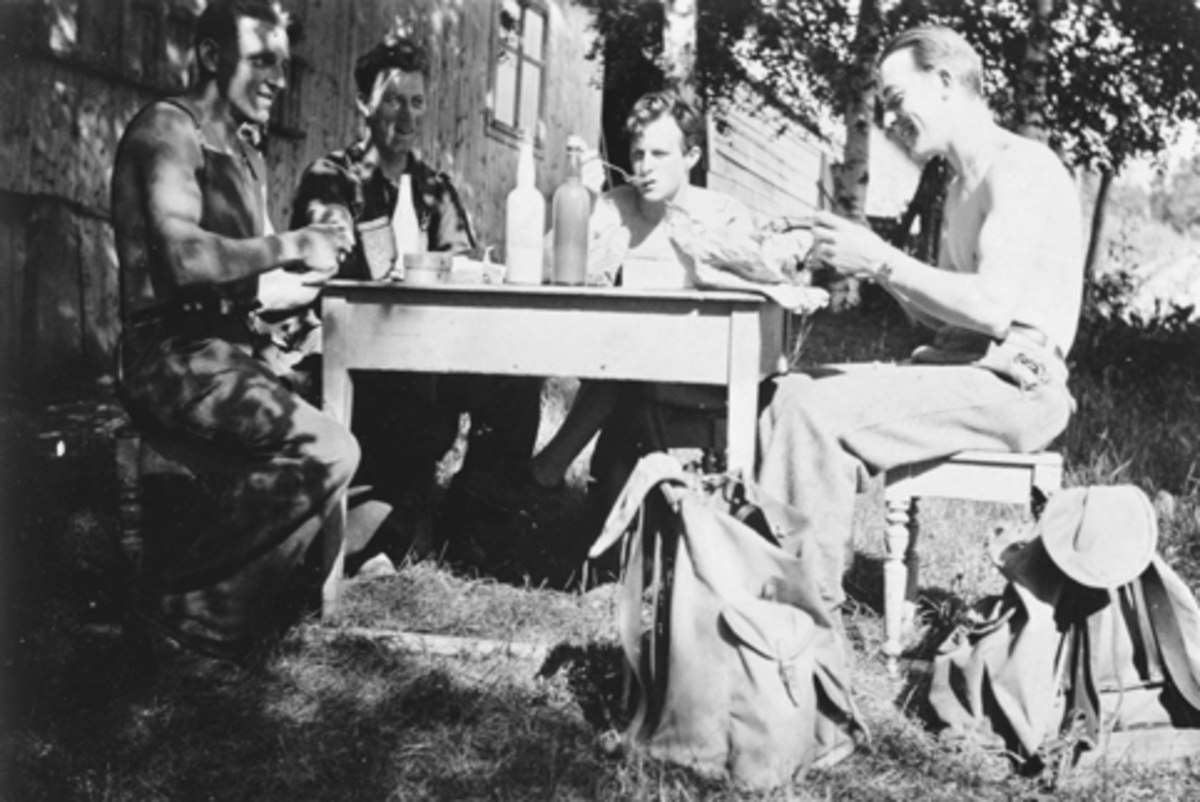 Anno Domkirkeodden, Nes Trevarefabrikk. Arbeidere med matpause ute i det fri. Nistepakke, flasker med melk. Ryggsekker. Fra venstre er Marius Pedersen fra Vallset, Arne Bakken, Leif Olufson, Einar Bøvolden. Ca. 1944.