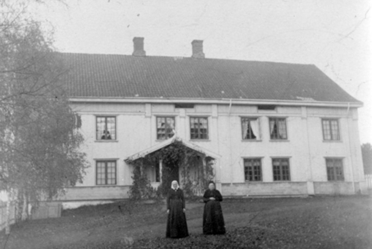 Anno Domkirkeodden, To ukjente kvinner foran hovedbygningen på Hoel gård, Nes, Hedmark.