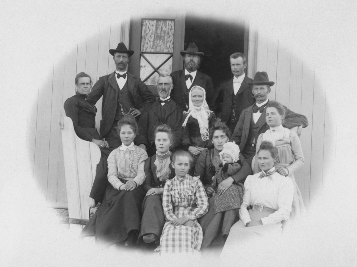 Anno Domkirkeodden, Stor familiegruppe på trappa ved hovedinngangen på Aske mellem, Nes, Hedmark. I midten er Anders Larsen Storlien (1838-1916) og hustru Agnethe Simensdatter Tretengen (1849-1910). Simen Andersen Storlien (1873-1940) med hatt til høyre. Foran ham sitter hans kone Anna Eriksdatter Hovie (1875-1960) me…