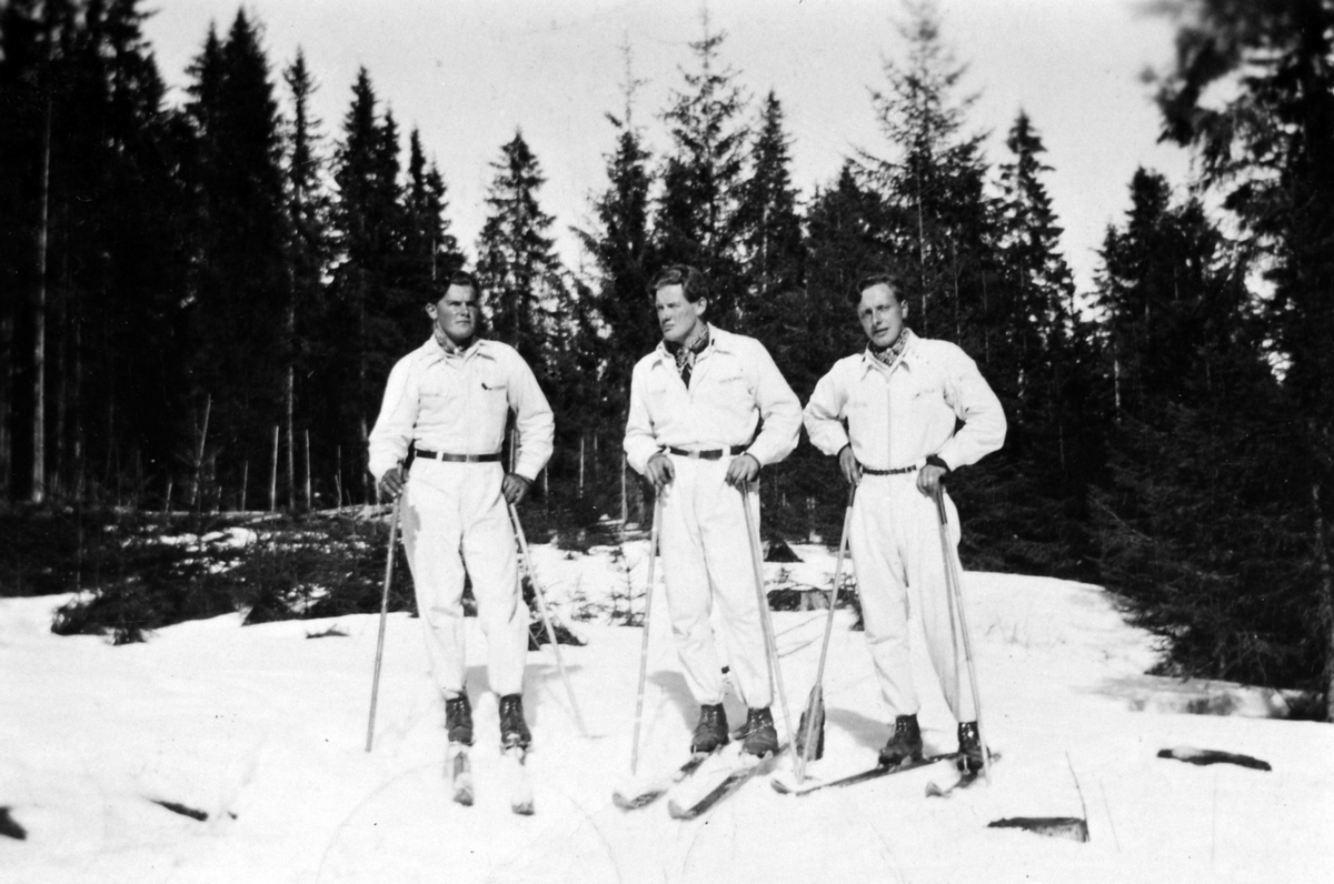 Anno Domkirkeodden, Ove Kaashagen, Sverre Kaashagen og Trygve Sønsteby i hvite dresser sydd av Oline Kaashagen, ski på beina.