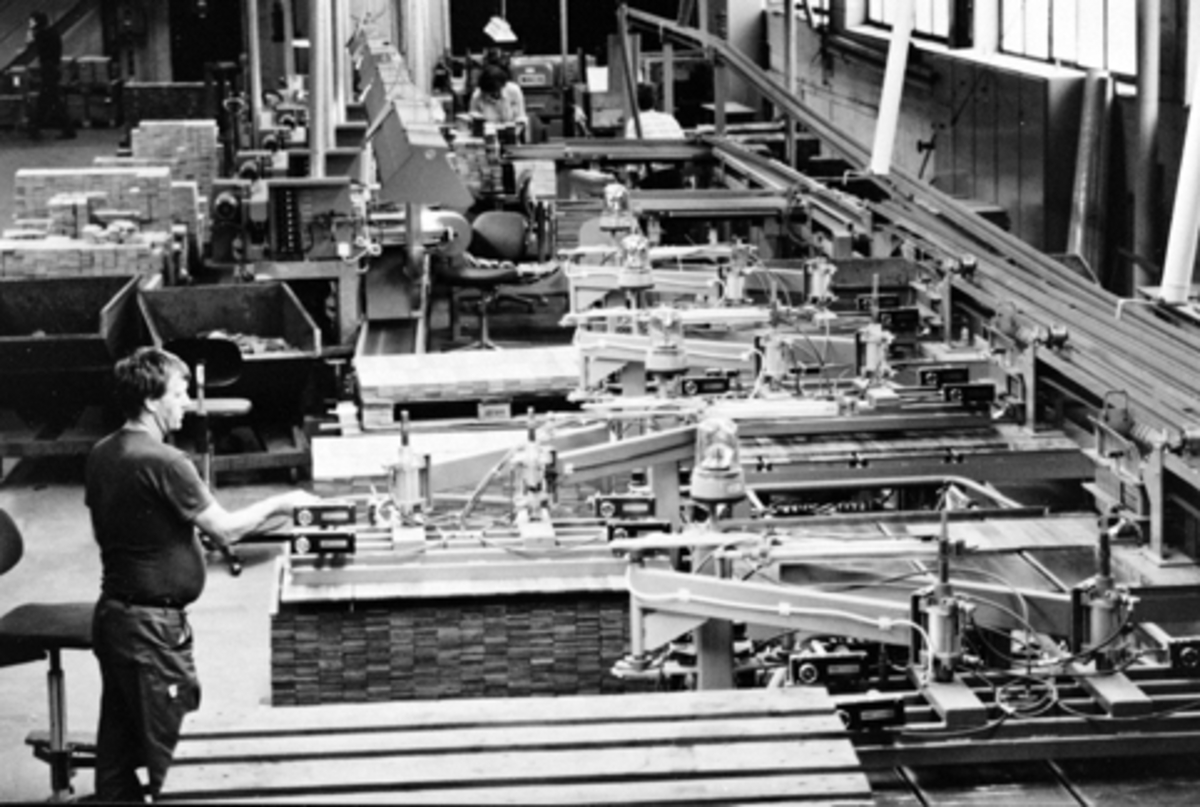 Anno Domkirkeodden, Berger Langmoen A/S, Brumunddal. Interiør, parkettfabrikken. Produksjon av parkett, Maskinen kontrolleres av Odd MArtin Olsen.
