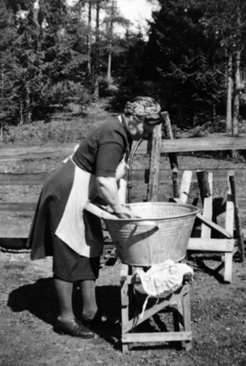 Anno Domkirkeodden, Marte Østeraas vasker klær utendørs i vaskebalje. Marte bodde i Kastbakken, Moelv. 1943.