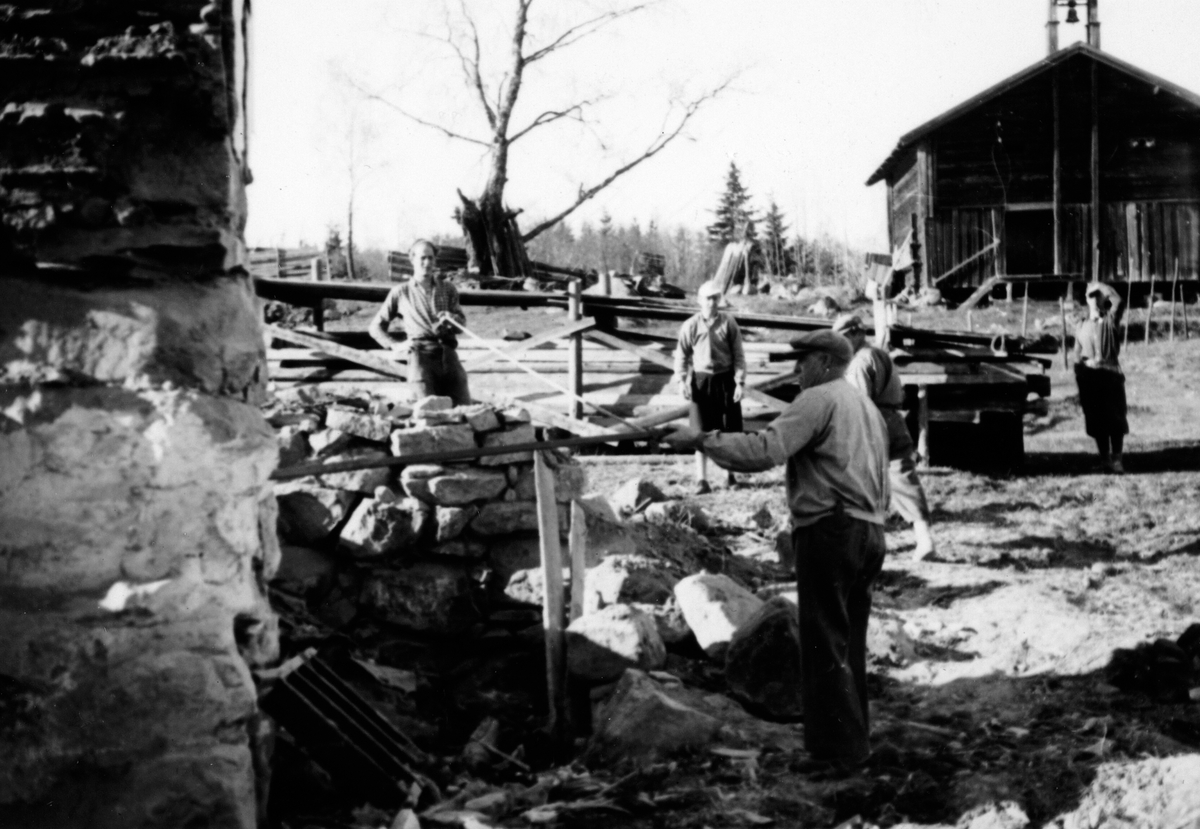 Anno Domkirkeodden, Grunnarbeid og muring. Førådsbygningen er revet (1952) og grunnarbeid for den nye hovedbygningen forberedes. Gardbruker Hans Medlien i forgrunnen. Stabburet fra 1700-tallet i bakgrunnen.