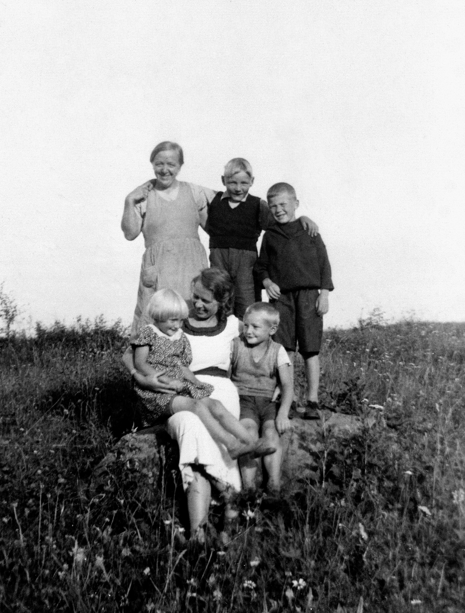 Anno Domkirkeodden, GRUPPE: 6 VOKSNE OG BARN, BAK FRA VENSTRE:THEA FØDT: 1899, JOHAN, JUL (JOHAN), FORAN: PERNILLE SAGEN MED ERIK FØDT: 1928 TIL VENSTRE: VESLA PÅ FANGET