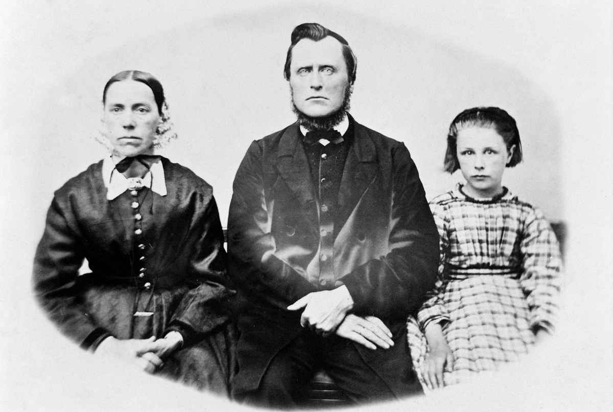 Anno Domkirkeodden, ANNE, PEDER OG MINA HELENE SIGSTAD FAMILIEGRUPPE, PORTRETT. MINA HELENE BLE FØDT I 1859, KVINNE, MANNSDRAKT, HODEPLAGG, ANNE HAR KAPPE PÅ HODET, 1860 ÅRENE.