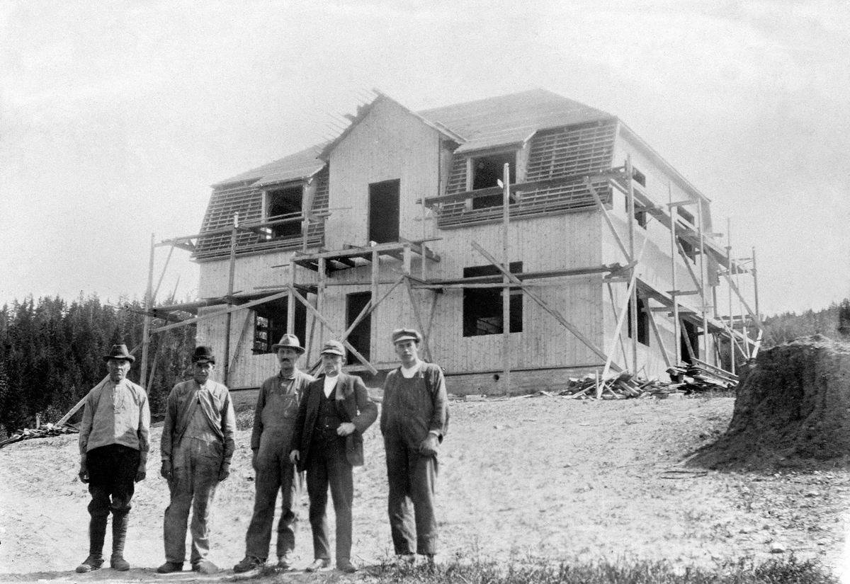 Anno Domkirkeodden, STANGE ALMENNINGS BESTYRERBOLIG "UTSIKTEN" UNDER BYGGING I 1921. BOLIGEN LIGGER RETT NEDENFOR HEIDTUN PÅ ESPA OG KOSTET 45000 KRONER DA DEN STO FERDIG. HUSBYGGING. GRUPPE: 5 MENN FORAN, FRA VENSTRE: UKJENT, ANTON ANDERSEN, EINAR STRANDSBERG, EIVIND ANDERSEN