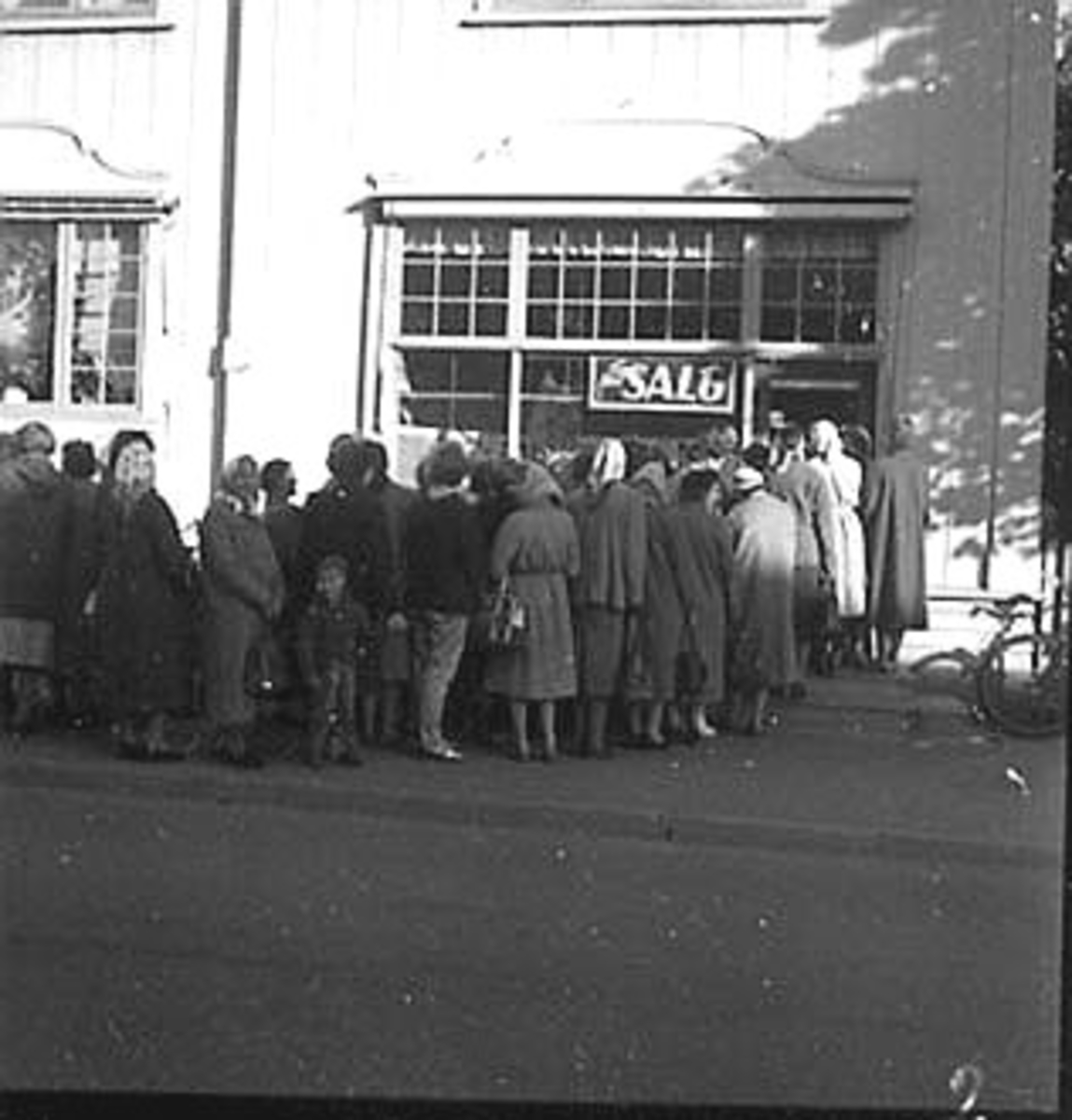 Anno Domkirkeodden, STOR GRUPPE: KØ MED FOLK FORAN GODAGER, AGNES FORRETNING, UTSALG ETTER PETTERSON, JOHN FORRETNING, STORGATA. ,