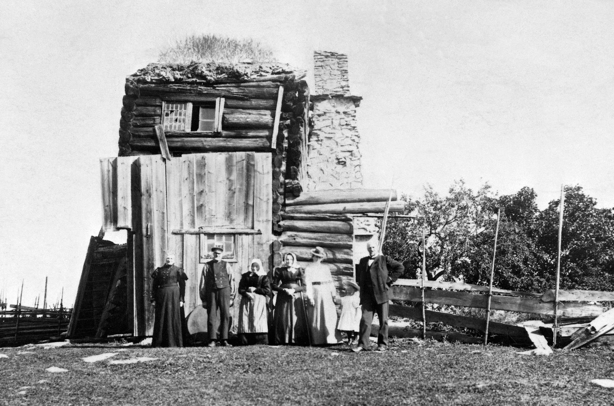 Normann Helger, EKSTERIØR: RESTER AV HUSEBYBYGNINGEN, FOLK FORAN, , HUSEBY, GAMMEL KONGSGÅRD. Rester av ramloftstua, før nedriving i 1933.