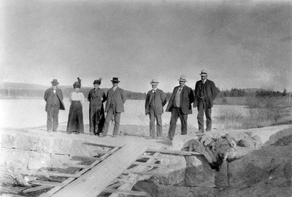Anno Domkirkeodden, FOSSEELVEN ELEKTRISITETSVERK DEMNINGEN VED DAMSAGA, HRASJØEN. HER ER EN DEL AV STYRET PÅ BEFARING SAMMEN MED SINE FRUER, FRA VENSTRE: UKJENT, EVINE BRYHNI, INGER BRYHNI, JOHAN P. BRYHNI, OLE GALGUM, PER SVINBERG, PER BRYHNI, DAMMEN VED HARASJØEN. SE BOKA" FOLK OG KRAFT STANGE ENERGI 1916-2006" S. 25