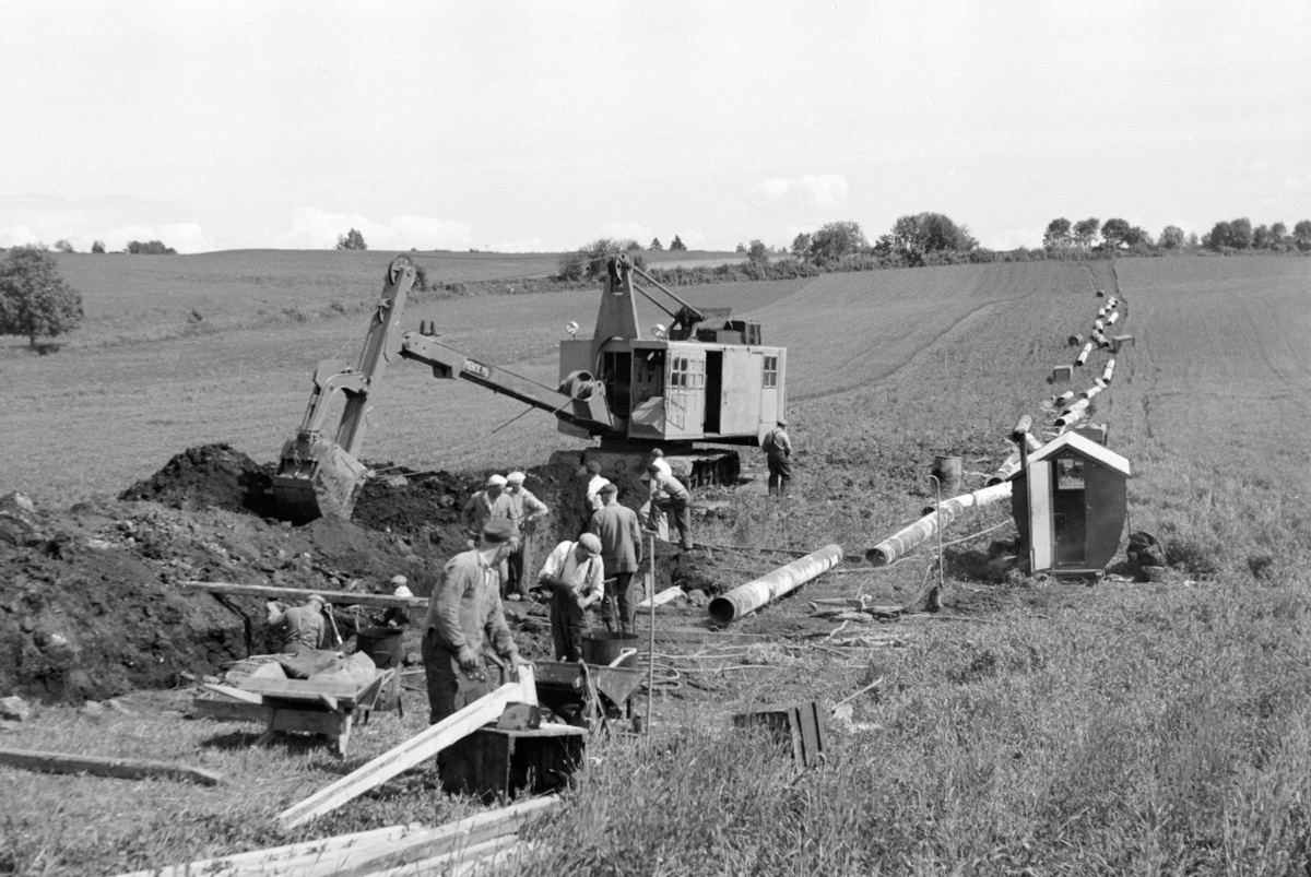 Anno Domkirkeodden, STANGE VANNVERK, LEGGING AV VANNLEDNING, MENN ARBEIDER, GRAVEMASKIN, RØR, HOVEDLEDNINGEN FRA MJØSA, FRA VENSTRE ÅSTRØM, H. JANSEN, H. SØRLI, G. BERGH, NYHAGEN, KASPERSEN, A. JENSEN, R. JENSEN.