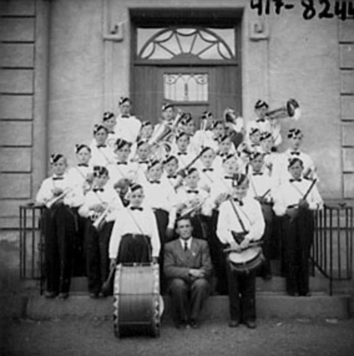 Anno Domkirkeodden, STOR GRUPPE, GUTTEMUSIKKORPS MED DIRIGENT PÅ TRAPP