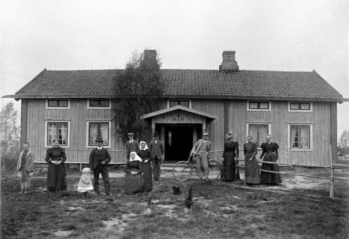 Anno Domkirkeodden, EKSTERIØR: GARDSBRUK, HOVEDBYGNINGEN HAUKAASEN, GRUPPE: 12 FRA VENSTRE: FOSTERBARN, MARGRETHE HAUKAASEN, BARN: BERTHA SERINE, ANDERS HAUKAASEN, PER HAUKAASEN, BERTHE MARIE SAASTAD, EVINE SAASTAD, ANDERS HAUKAASEN, EVEN SAASTAD MED SYKKEL, BERTA SAASTAD, FRØKEN HAMMERSTAD, FRU HAMMERSTAD.