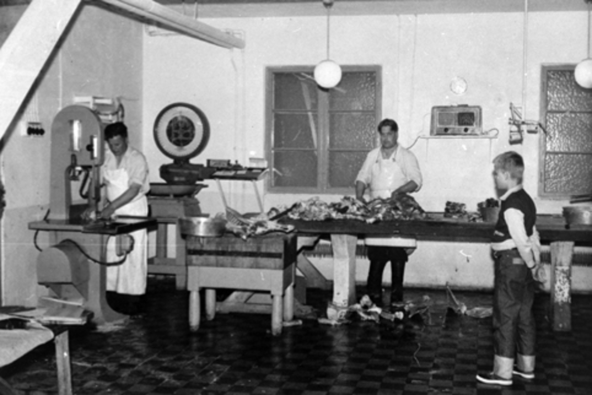 Anno Domkirkeodden, BROVOLD SLAKTERI OG PØLSEMAKERI, STANGE I 1950-ÅRENE. ALF BROVOLD I ARBEID VED KJØTTSAGA, OG ARVID BROVOLD VED BENKEN. T. H. UKJENT. SE STANGE HISTORIELAGS ÅRBOK"GAMMALT FRA STANGE OG ROMEDAL 2009" S. 76.