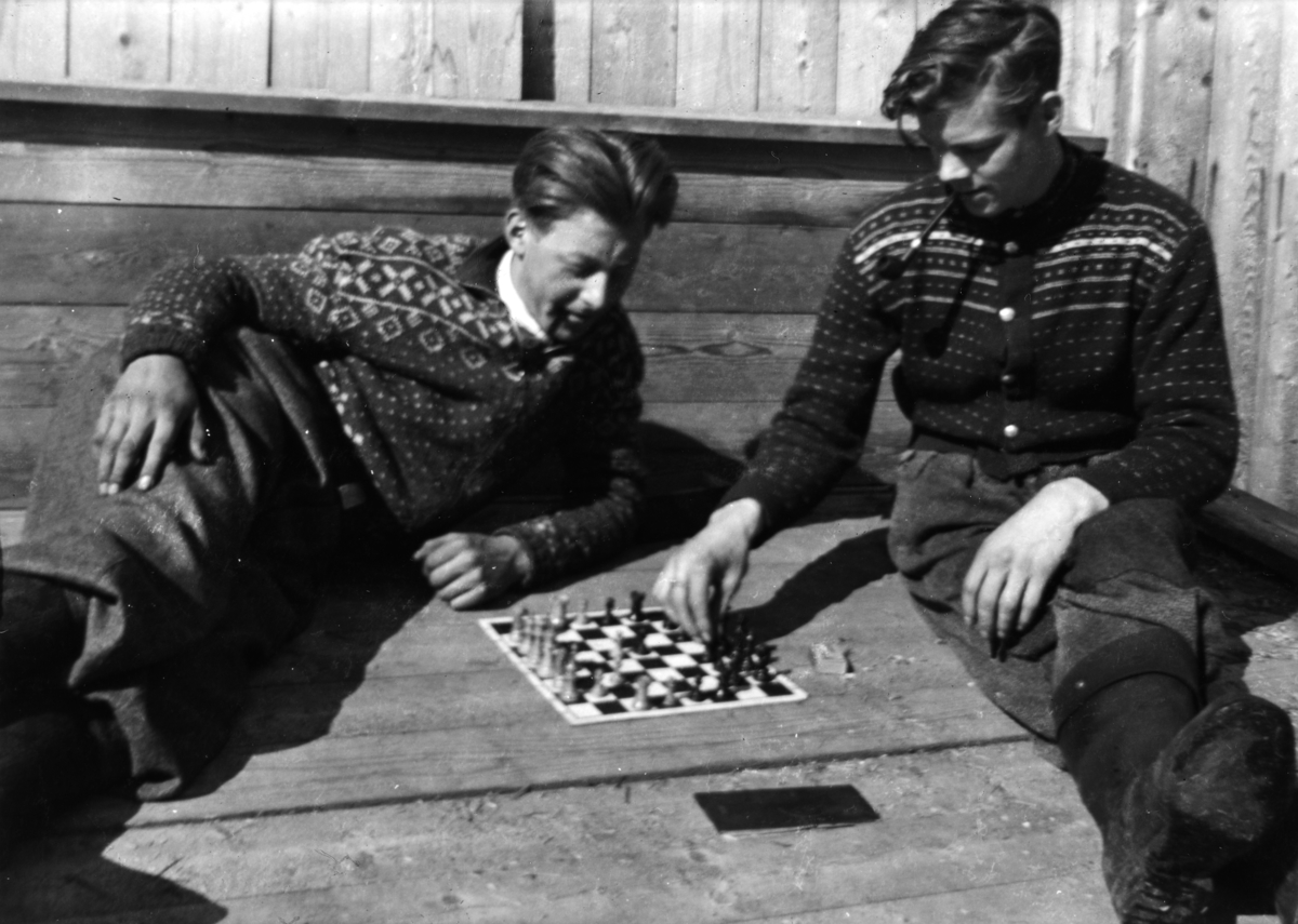 Ukjent, Fossengen nordre i Vallset ca. 1937-1938. "Dugurdskvile. " Einar Østby og Oskar Lier slapper av med ei pipe og et parti sjakk. Brettspill.
