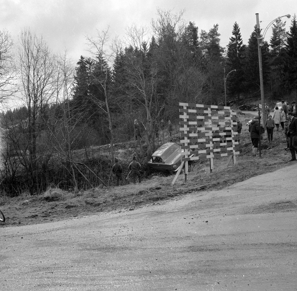 Adolf Skjegstad, BILULYKKE, PERSONBIL FORD CORTINA C-71150 I GRØFTA, RASCHS VEI, OSLO. 'bunnen' av Raschs vei i øst der hvor motorveien idag ligger. Kan også skimte en av skihoppene til Bækkelagsbakken i venstre billedkant.